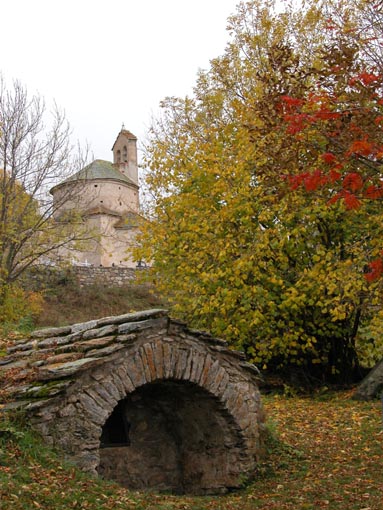 L'glise de Plans vue depuis une petite fontaine.