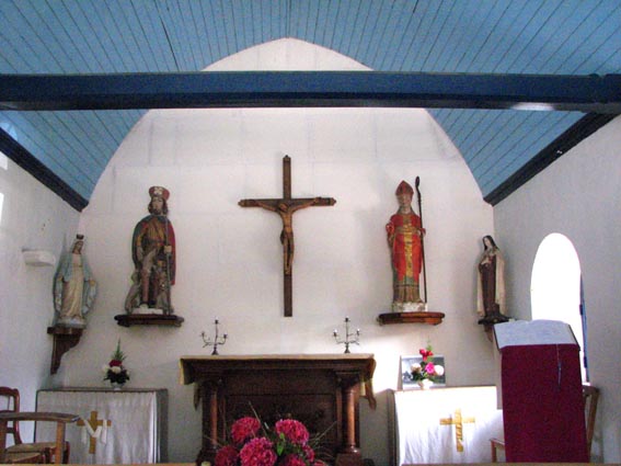 L'intrieur est lambriss avec des poutres  entraits; on y trouve les statues de Saint Martin et Saint Roch.