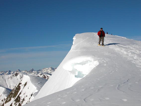 Jean Pierre longe une corniche en dessous du sommet de Canaourouye.