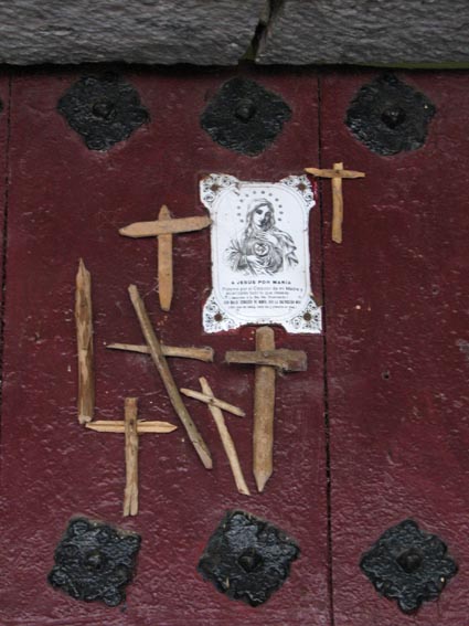 Croix fixées sur les portes par des pèlerins de Saint Jacques.