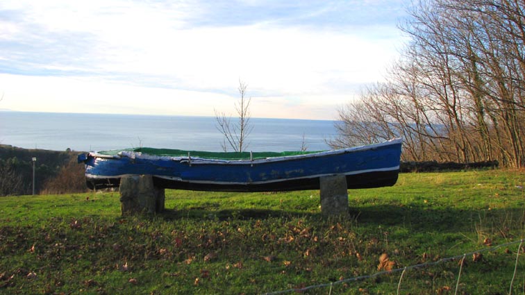 Une vieille barque bleue posée sur socles, qui a fait plus que son temps...