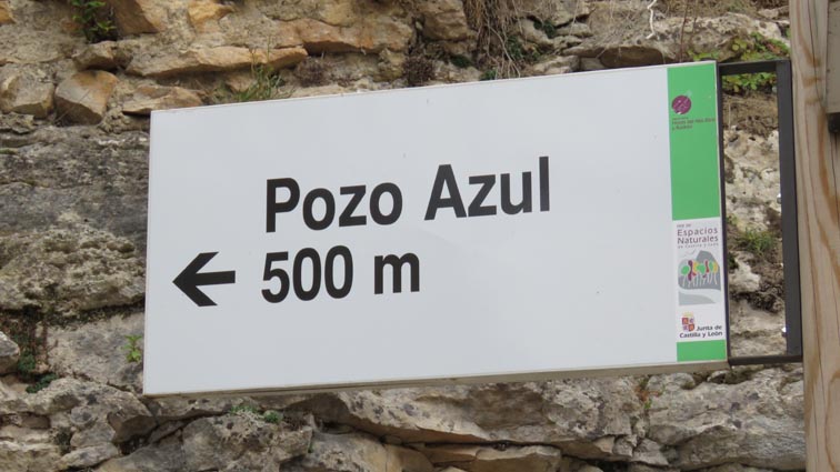 En face d'un pont, un panneau indique le Pozo Azul à 500m en face de nous