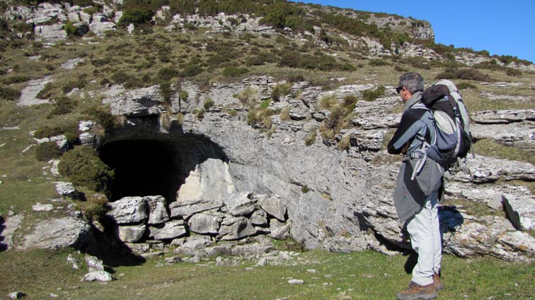 Nous passons à côté de l'entrée d'une grotte en forme de tunnel, dont l'entrée est plus ou moins protégée par un cordon de rochers