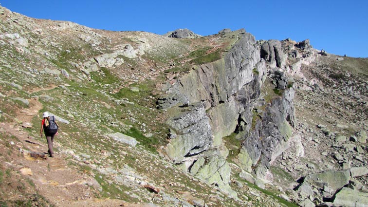 Le sentier part en traversée sur la droite pour s'élever au-dessus d'une barre rocheuse verticale.